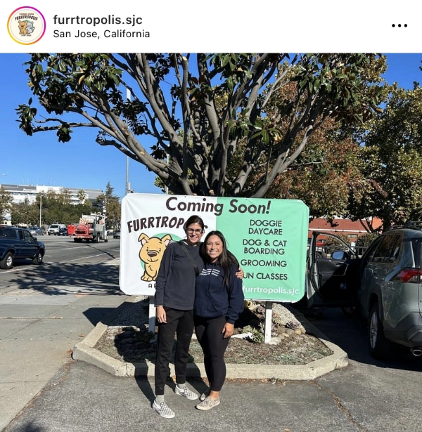 Two people standing in front of a sign that says Furrtropolis coming soon, featuring services like Dog daycare and Cat boarding.